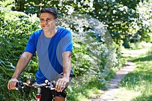 Mature Man Cycling Along Path In Countryside