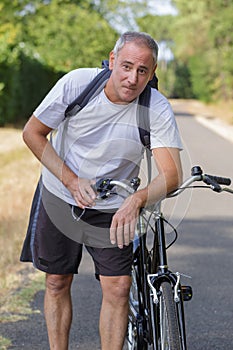 Mature man cyclist next to bicycle