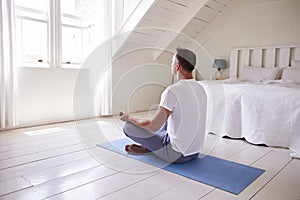 Mature Man With Digital Tablet Using Meditation App In Bedroom