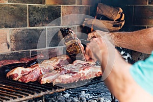 Mature man doing a barbecue. Prodding the meat with a fork photo