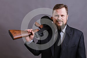 Mature man dressed in suit with tommy gun