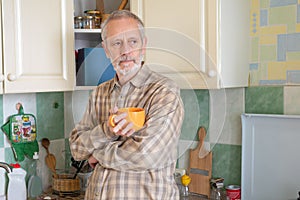 Mature man drinking his coffee in kitchen