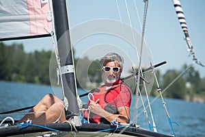 Mature man enjoying sailing on hobie cat boat