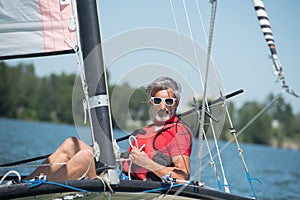 Mature man enjoying sailing on hobie cat boat photo