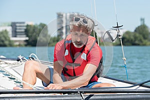 Mature man enjoying sailing on lake