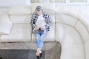 Mature man enjoys music with a laptop on sofa
