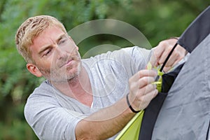 mature man erecting tent
