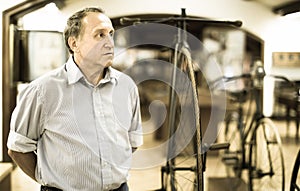 Mature man examines the exhibit in museum