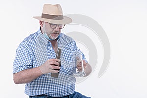 Mature man excitedly holding an empty beer glass and beer bottle: Selective focus. Leisure concept.