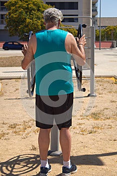 mature man doing sports on the street with sports machine