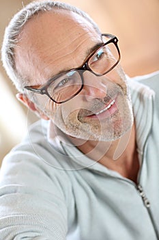 Mature man with eyeglasses relaxing at home
