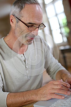 Mature man with eyeglasses using keyboard