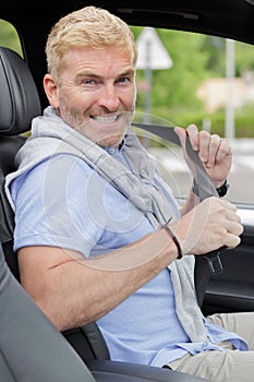 mature man fastening seatbelt