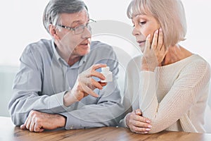 Mature man giving his wife some pills