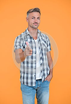 mature man with grizzle hair on yellow background. point finger