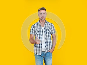 mature man with grizzle hair on yellow background. thumb up