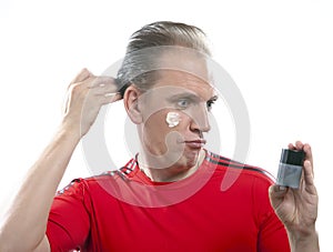 The mature man has reflected on application of a man's cream against wrinkles