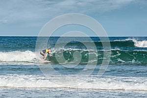 mature man having fun surfing the waves of the atlantic ocean