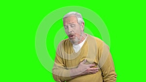 Mature man with heart attack, green screen.