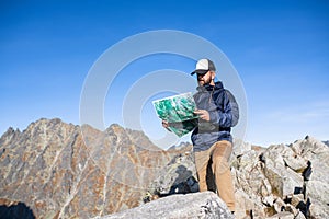 Zrelý muž turistika v horách v lete, pomocou mapy.