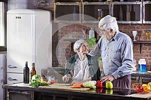 Mature man and his mother cooking together. Senior couple preparing meal in kitchen