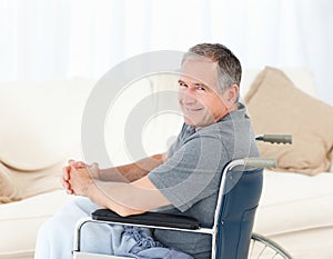 Mature man in his wheelchair looking at the camera