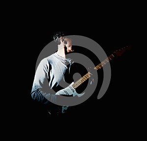 Mature man holding an acoustic guitar against black background. Portrait of a mature man holding an acoustic guitar