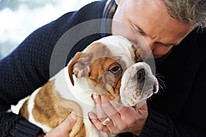 Mature Man Holding English Bulldog Puppy