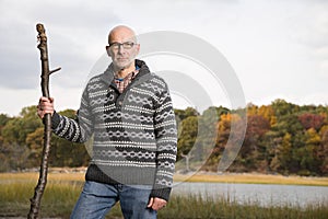 Mature man holding a stick