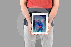 Mature man holding tablet with urinary system photo