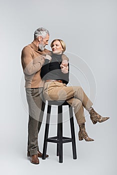 Mature man hugging stylish wife sitting
