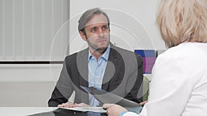 Mature man with joint pain talking to his doctor after x-ray scanning