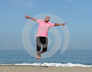 Mature man jumping on beach