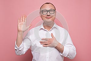 Mature man keeping hand on chest making promise, swearing to tell the truth