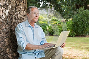 Mature man with a laptop looking into the sky