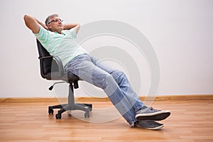 Mature man leaning back in swivel chair
