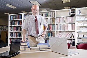 Mature man at library table with textbooks