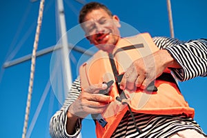 Mature man in a life jacket on a yach feeling good