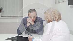 Mature man listening attentively to his doctor at medical appointment