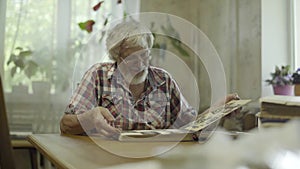 Mature man looking his old photos from youth