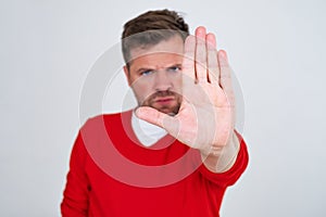 Mature man looking serious showing open palm making stop gesture