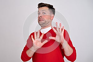 Mature man looking serious showing open palm making stop gesture