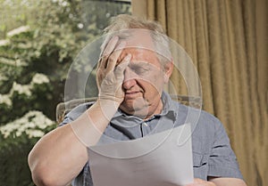 Mature man looking stressed reading a letter