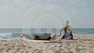 Mature man lying on surfboard, practicing paddling