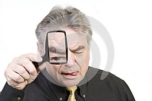 Mature Man with Magnifying Glass