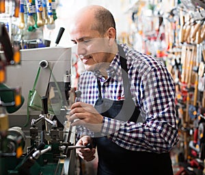 Mature man making duplicates of keys