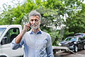Mature man making a phone call after a car accident. Copy space.