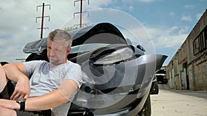 Mature man making a phone call after a car accident, damage car in the background. Close up