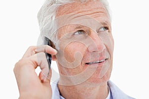 Mature man making a phone call while looking up