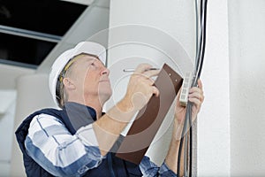 Mature man performing inspection electrical installation